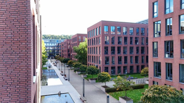 Moderne Wohnanlage mit roten Klinkerriemchenfassaden und gepflegten Grünflächen im Innenhof