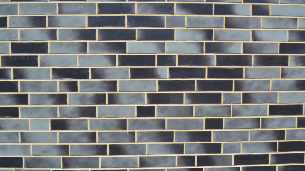 Moderne Klinkerriemchenfassade mit blauen und grauen Steinen in versetztem Verband mit hellen Fugen