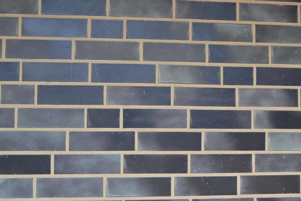Blaue Klinkerriemchen in verschiedenen Nuancen an einer Hausfassade mit heller Verfugung im Läuferverband