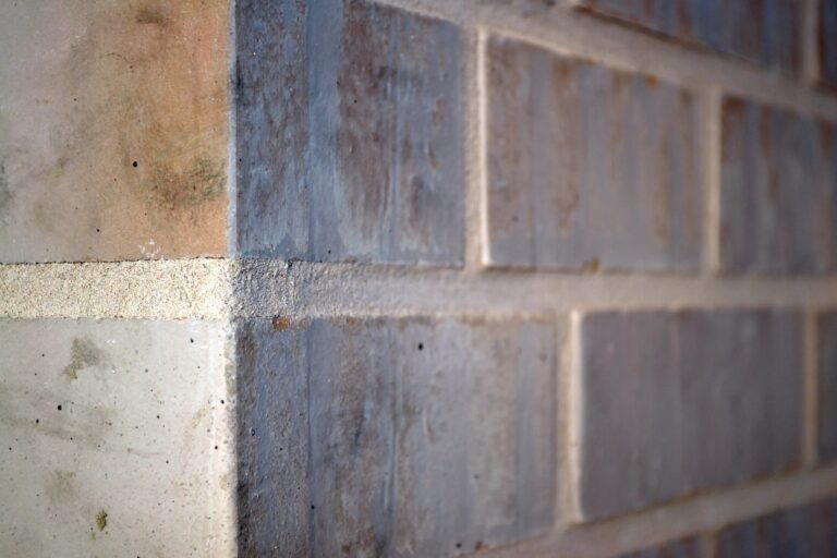 Nahaufnahme einer Klinkerriemchenfassade mit beigen und grauen Steinen in geometrischem Muster