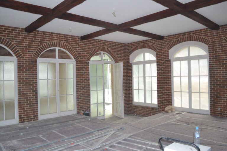 Innenraum mit Klinkerriemchen-Wandverkleidung, Rundbogenfenstern und Holzbalkendecke während der Bauphase