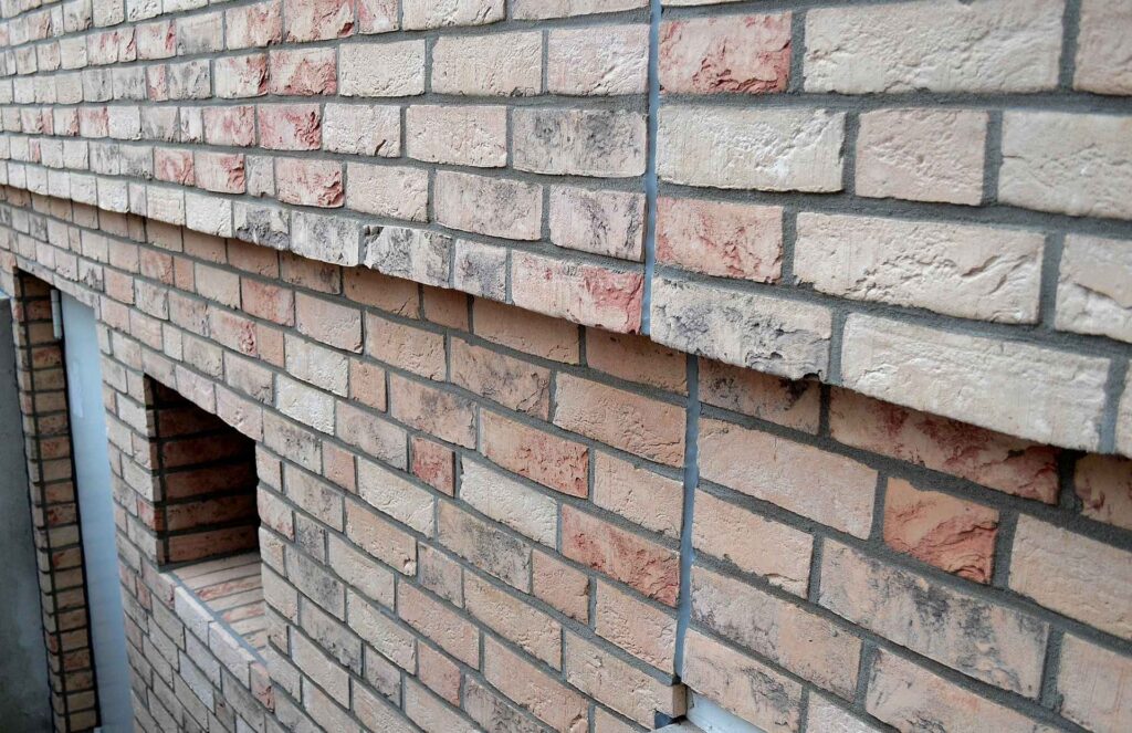 Klinkerová pásková fasáda s poškozením - odpadávající klinkerové pásky na zateplené fasádě domu