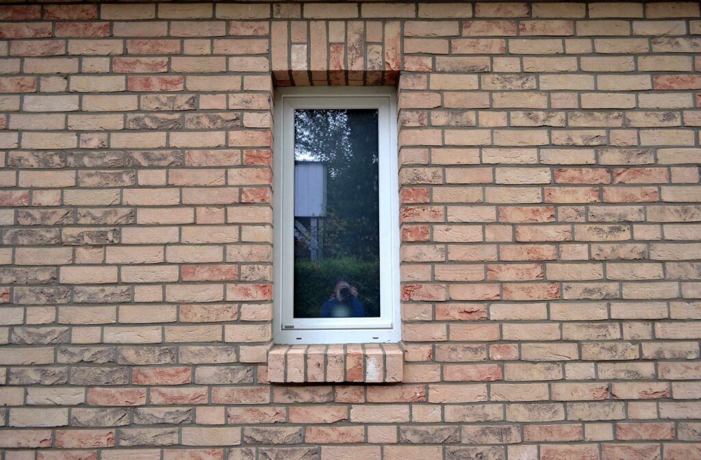 Klinkerová pásková fasáda s úzkým oknem, cihlové obkladové pásky v teplých odstínech