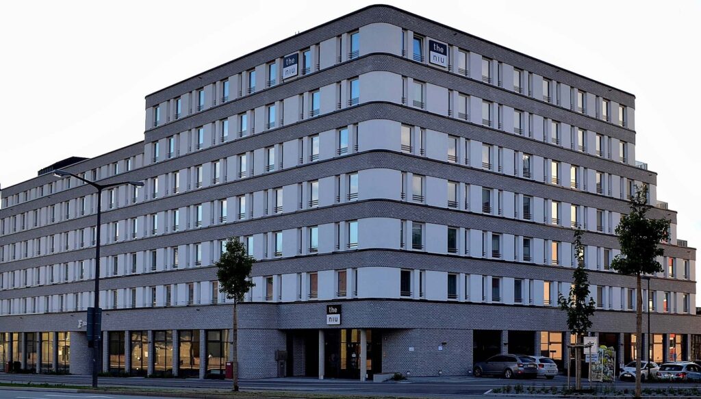 Moderní hotel s klinkerovou páskovou fasádou a velkými okny, vícepodlažní budova s kontaktním zateplovacím systémem