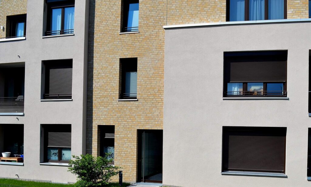 Moderní bytový dům s kombinovanou fasádou z klinkerových pásků a omítky s tmavými okenními rámy