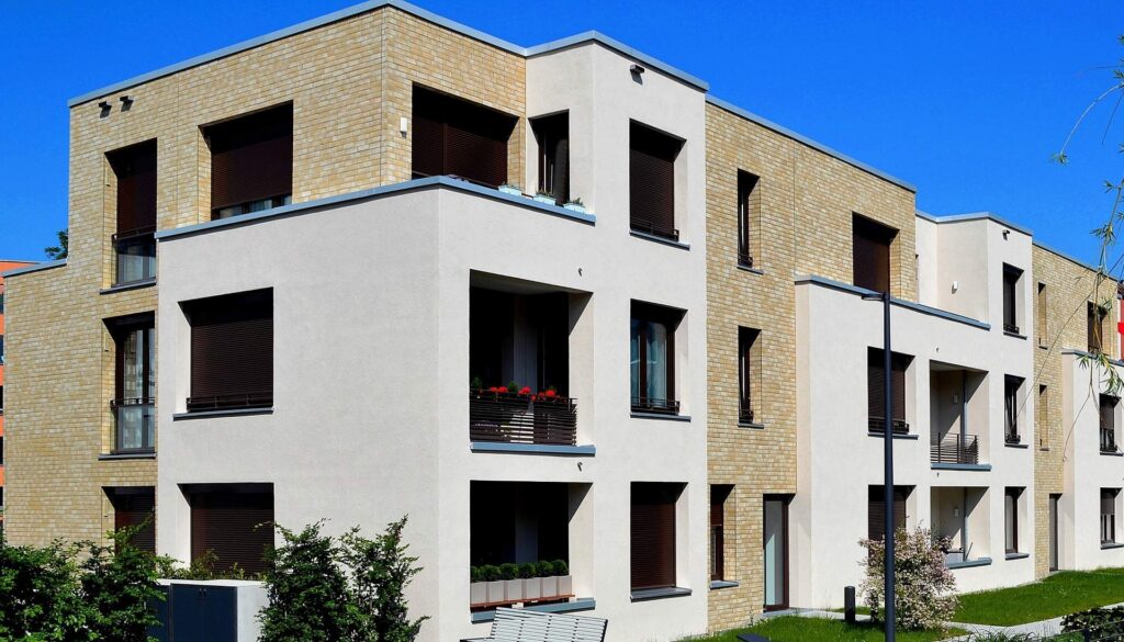 Moderní bytový dům s kombinovanou fasádou z klinkerových pásků a bílé omítky, trojpodlažní budova