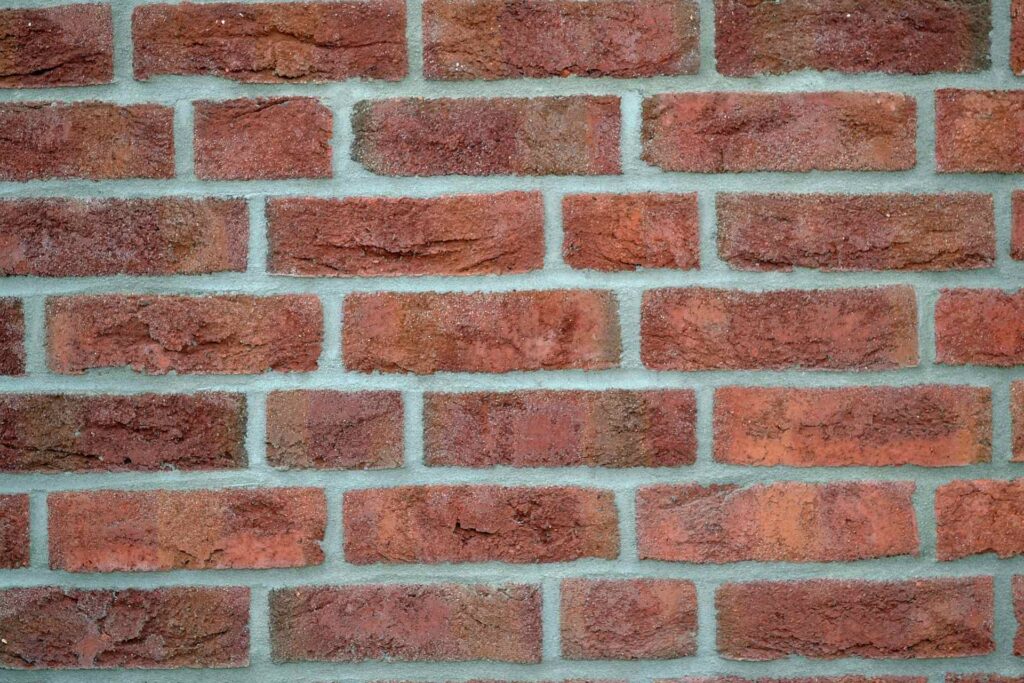 Fasáda z klinkerových pásků s cihlově červenými obkladovými pásky a světlou spárovací hmotou