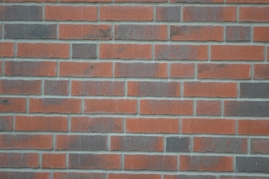 Fasáda z klinkerových pásků v červeno-hnědých odstínech se světlými spárami na zdi domu