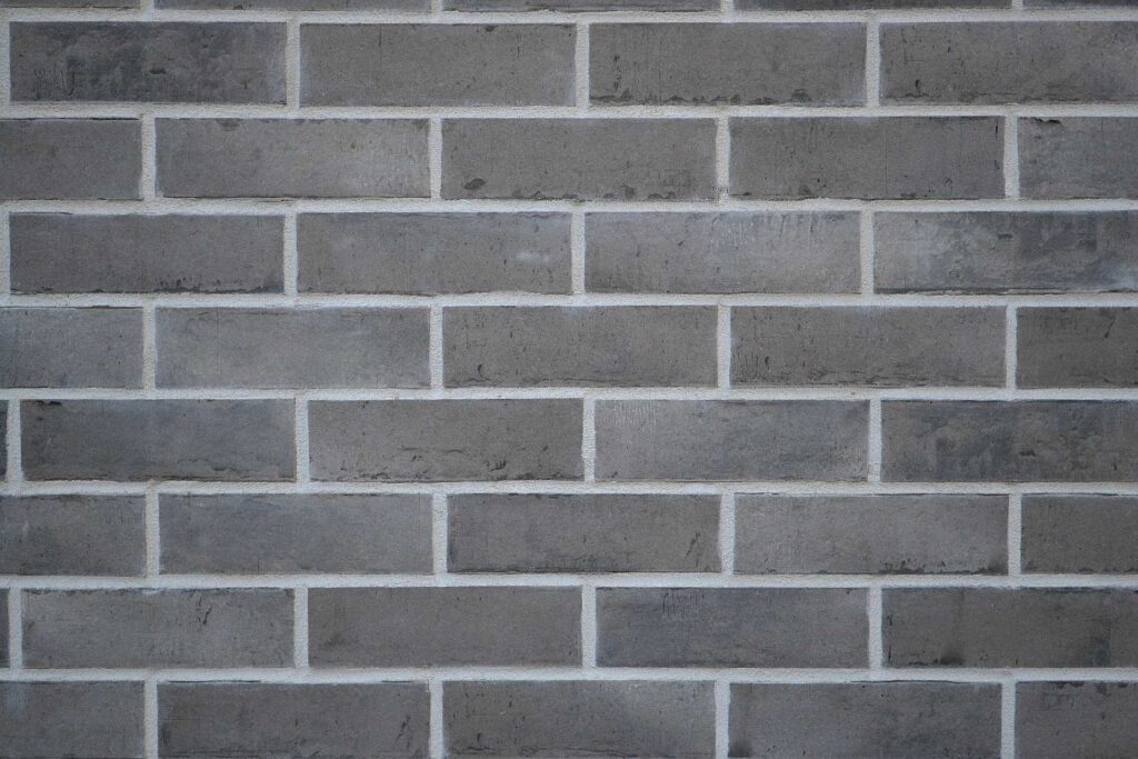 Fasáda z šedých klinkerových pásků s bílými spárami, detail cihlové páskové fasády moderního domu