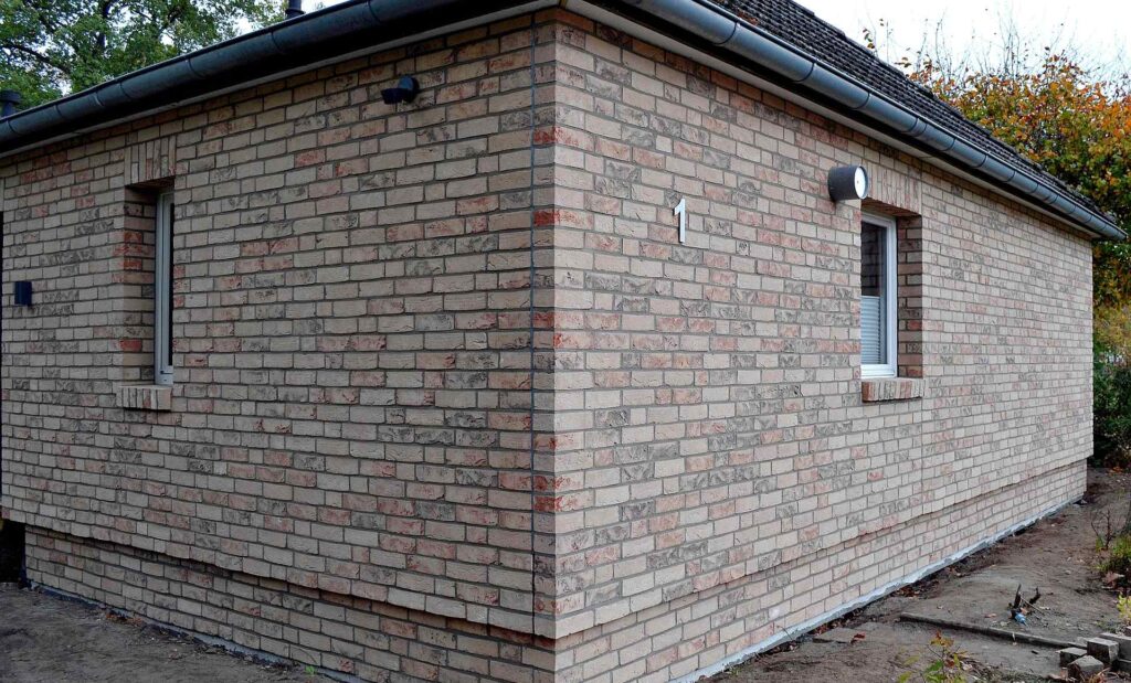 Novostavba rodinného domu s klinkerovou páskovou fasádou v barevném mixu béžových a červených odstínů