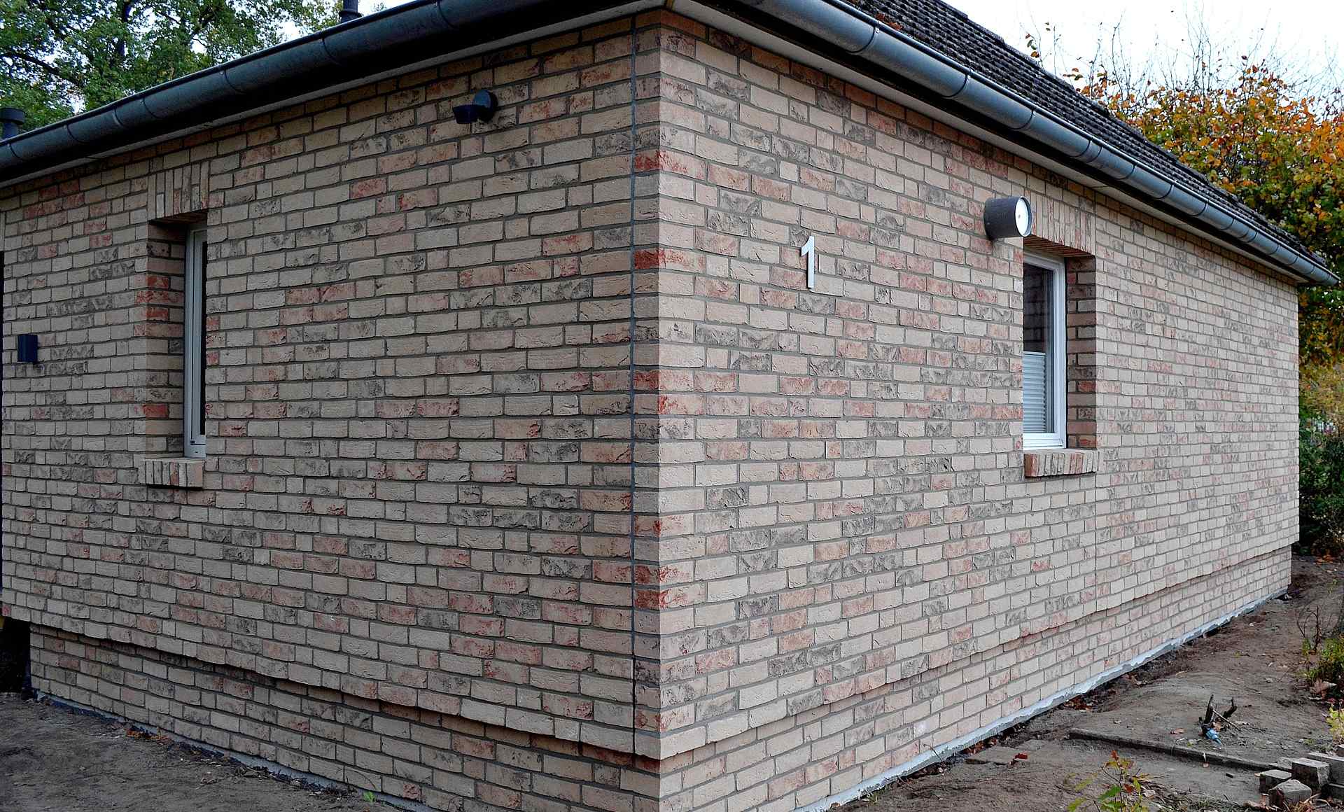 Moderní rodinný dům s klinkerovou páskovou fasádou v odstínech béžové a hnědé s plastovými okny