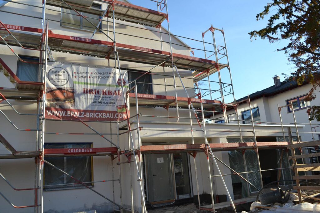Zateplení fasády domu s lešením během rekonstrukce - aplikace kontaktního zateplovacího systému